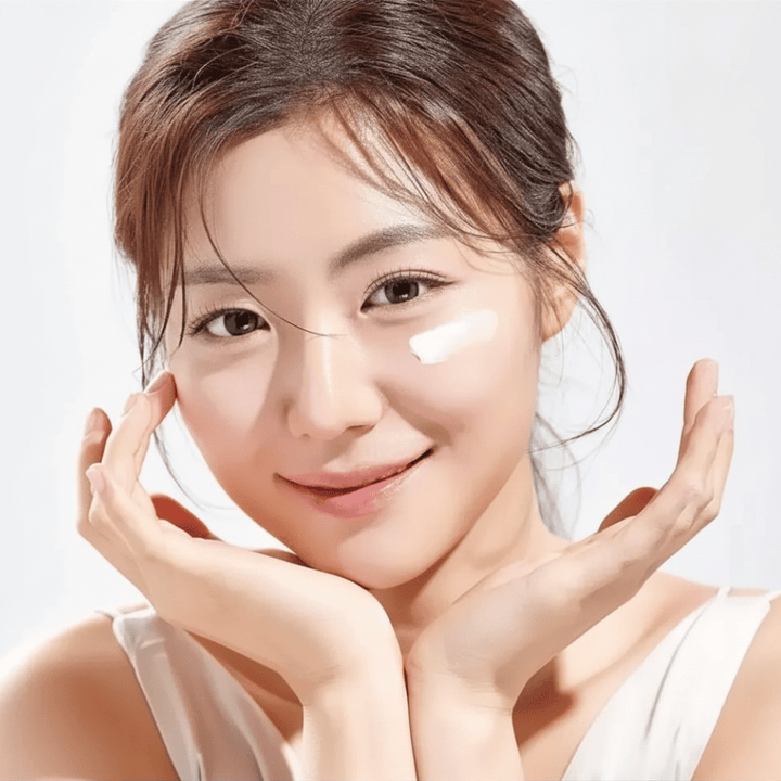 Woman applies Round Lab 1025 Dokdo Eye Cream under the eyes for hydration, radiance, and a more even skin tone