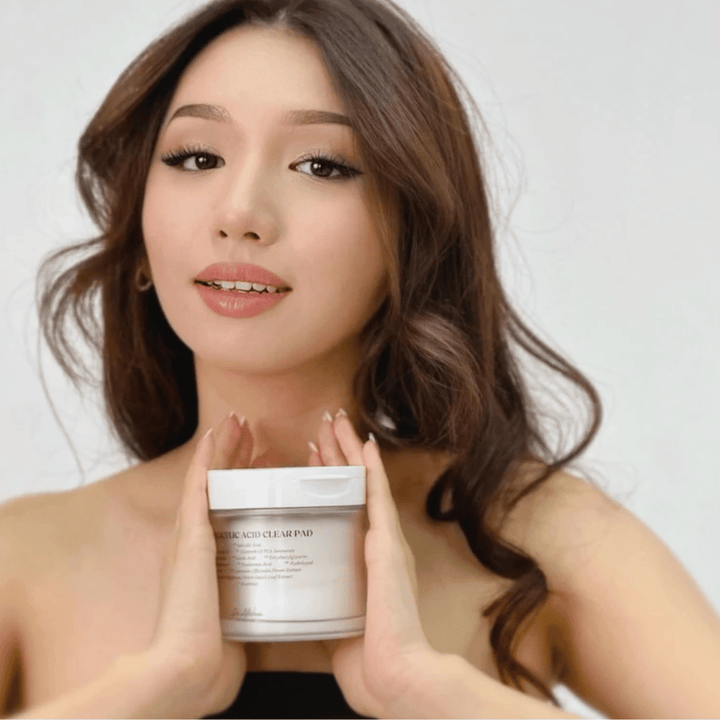 Model holds Dr. Althea 2% Salicylic Acid Clear Pad in front of the face. Exfoliating toner pads with salicylic acid that cleanse pores, balance sebum, and provide clearer skin.