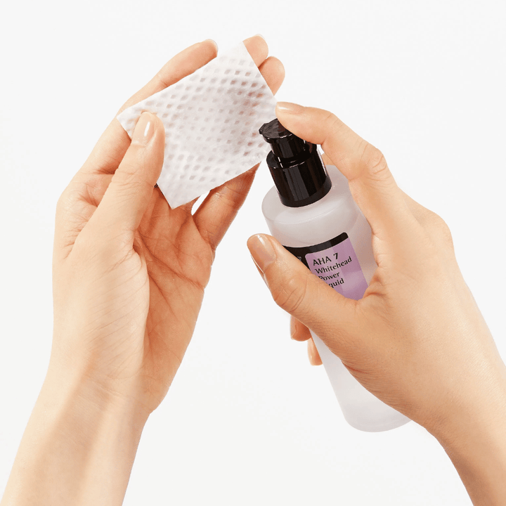 Application of COSRX AHA 7 Whitehead Power Liquid on cotton pad, exfoliating toner with AHA to remove dead skin cells and improve skin texture.