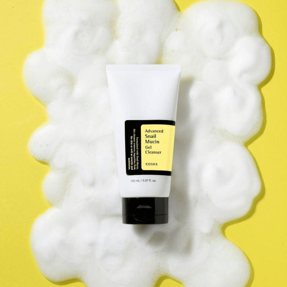 COSRX Advanced Snail Mucin Gel Cleanser 150 ml surrounded by abundant foam on a yellow background – mild Korean face wash with snail mucin for hydration and radiance.