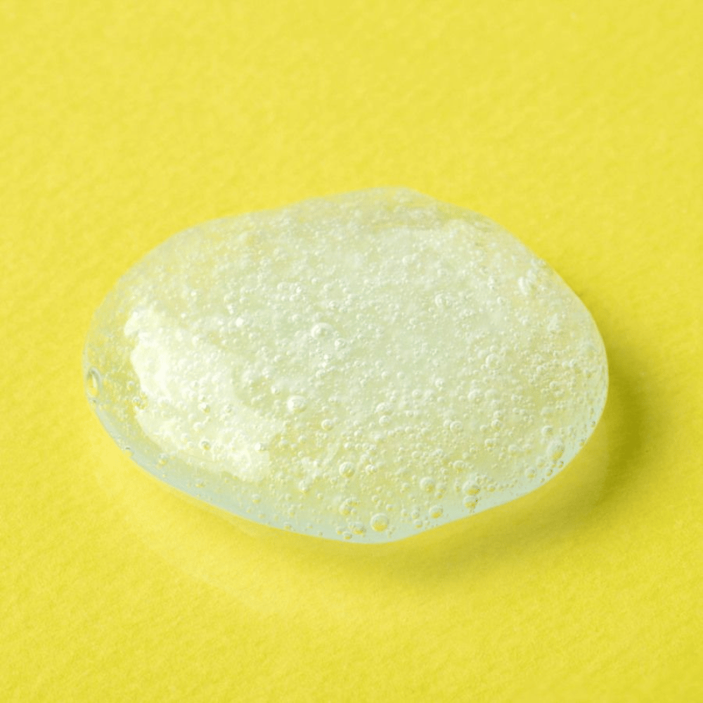 Transparent gel texture from COSRX Advanced Snail Mucin Gel Cleanser on a yellow background – moisturizing face wash with snail secretion for soft and balanced skin.