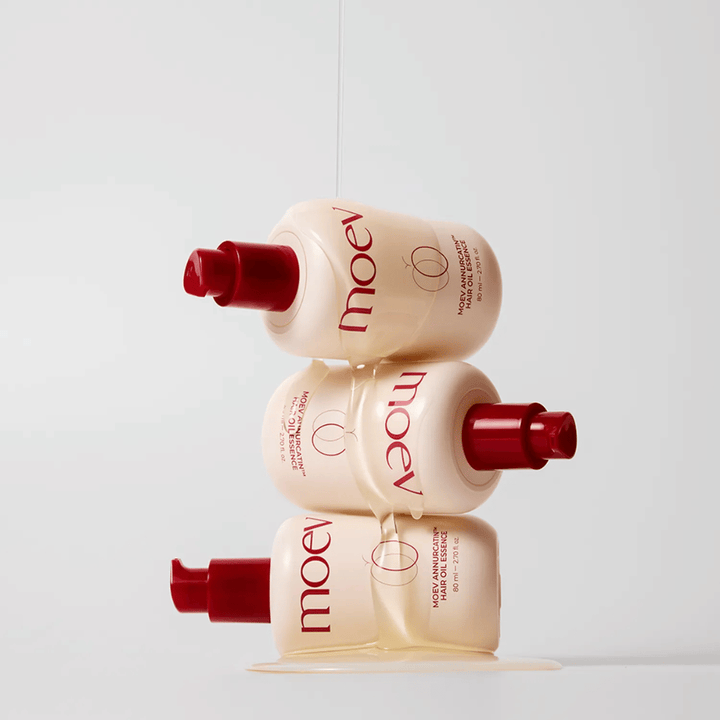 Tre flaskor MOEV Annurcatin Hair Oil Essence staplade – näringsrik hårolja med Annurca-äpple och biotin som stärker, skyddar och ger håret glans och elasticitet.