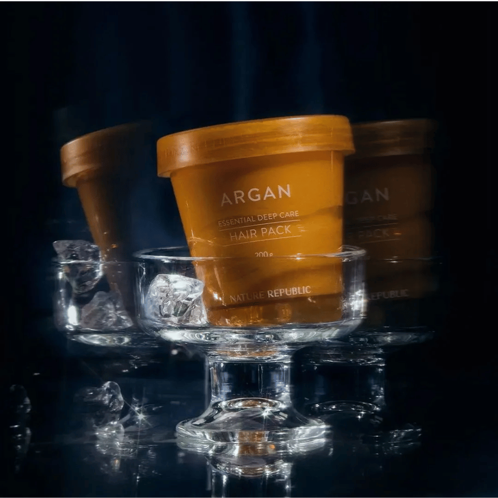 Nature Republic Argan Essential Moisture Repairing Hair Mask placed on glass dish with ice cubes – luxurious and nourishing hair mask.