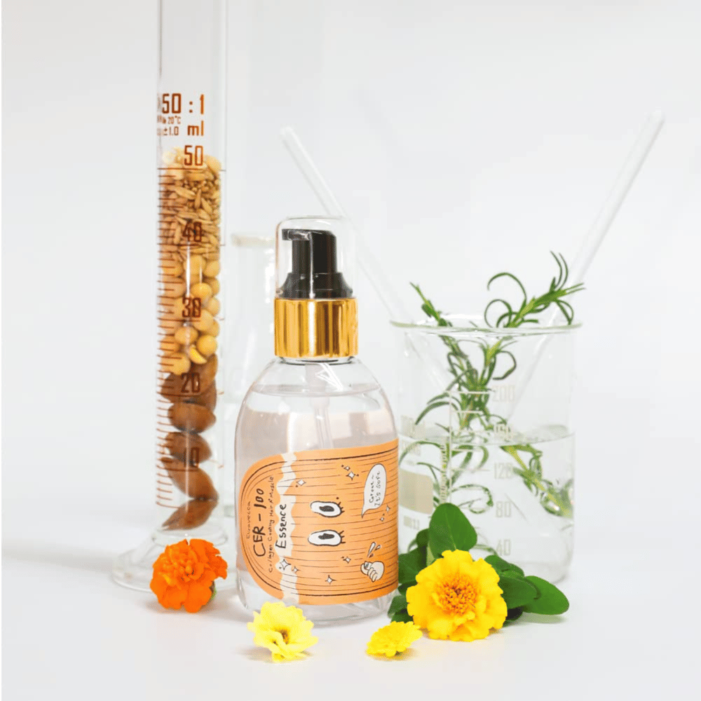CER-100 Hair Essence together with flowers and laboratory glassware highlighting ingredients and hair care.