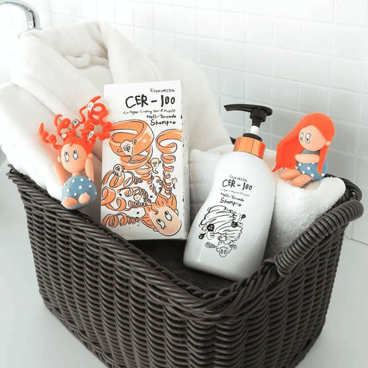 Presentation image with Elizavecca CER-100 Shampoo and product packaging placed in a basket together with towels. Playful figures from the packaging design highlight the brand's unique and creative style.
