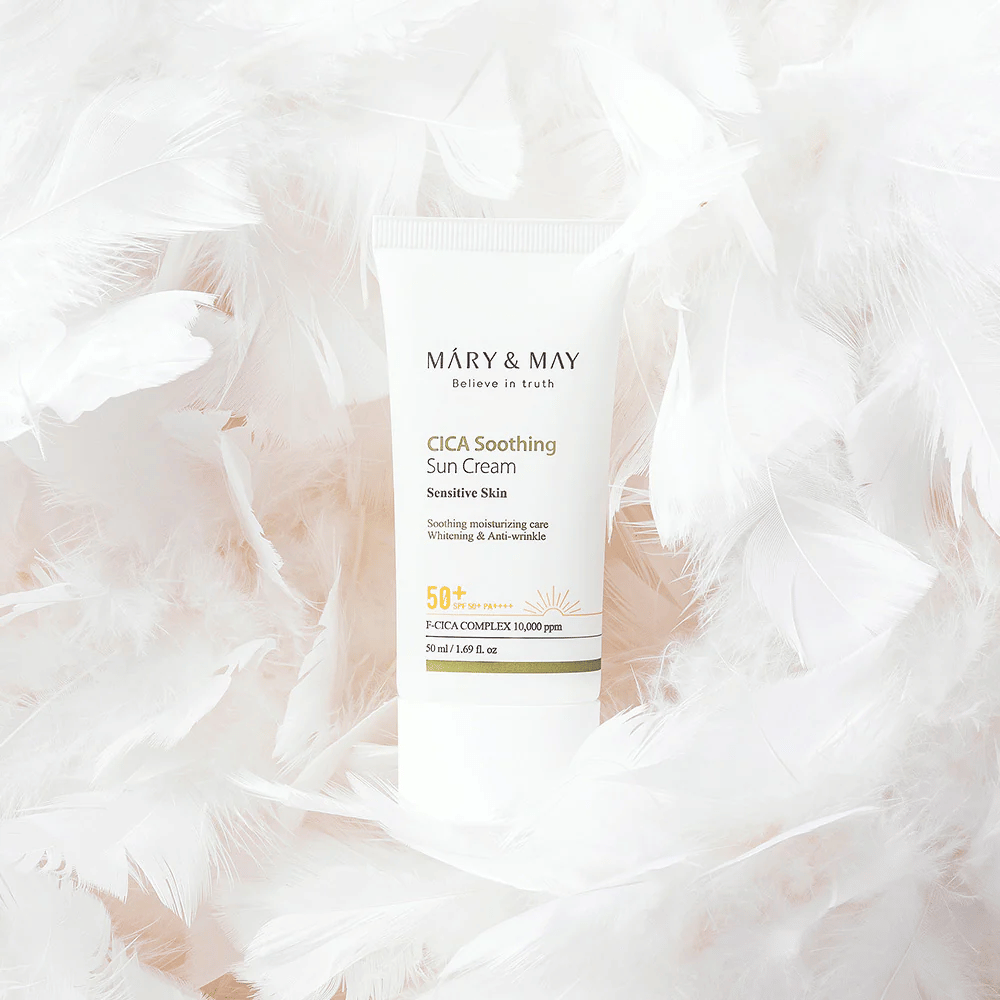 Mary&May CICA Soothing Sun Cream surrounded by soft white feathers. The image conveys a sense of gentleness, comfort, and a lightweight formula adapted for sensitive skin.