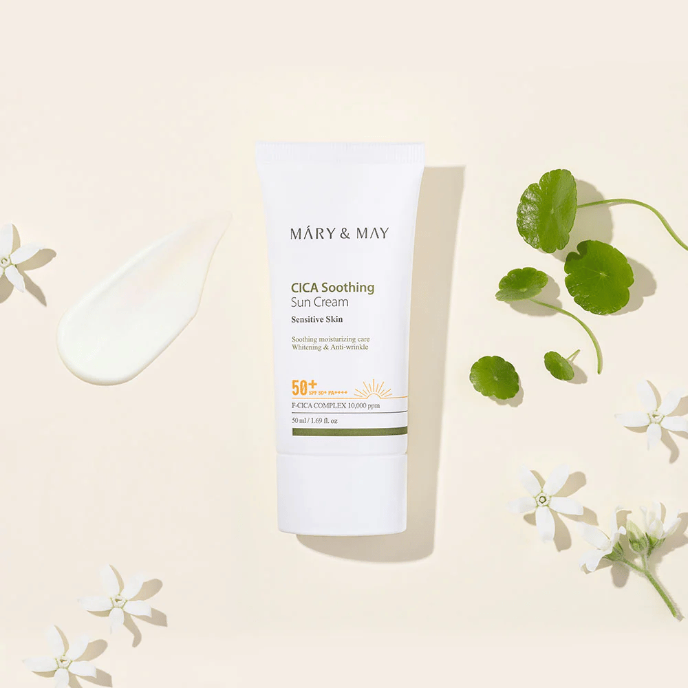Mary&May CICA Soothing Sun Cream SPF50+ PA++++ presented together with a cream texture, centella leaves, and white flowers. The image highlights the product's soothing properties and focus on sensitive skin.