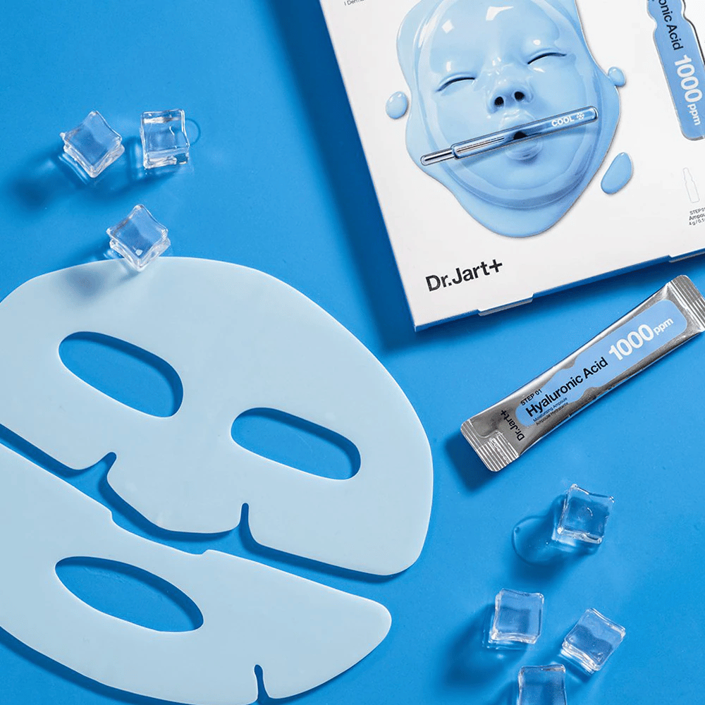Dr.Jart+ Cryo Rubber Moisturizing Mask with two-part blue rubber mask, ice cubes, hyaluronic acid ampoule and packaging against a blue background.