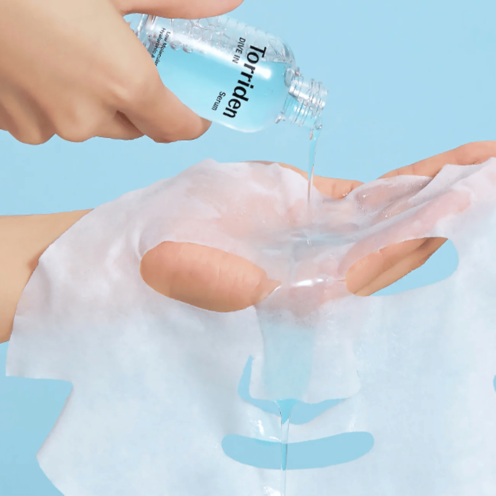 Face mask dr moistened with solution from a bottle "Torriden Dive-In", against a blue background.