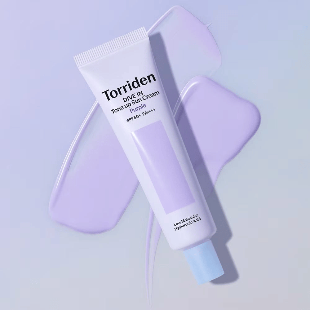Torriden DIVE IN Tone Up Sun Cream Purple placed on smeared purple cream that emphasizes the tone-evening and radiance-enhancing effect.
