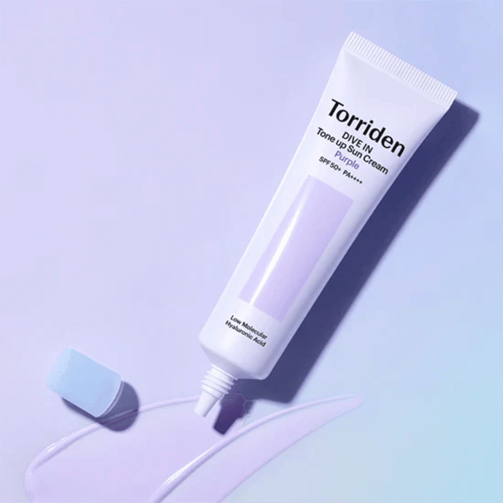 Open tube of Torriden DIVE IN Tone Up Sun Cream Purple with purple-tinted sunscreen texture showing the product's color-correcting formula.
