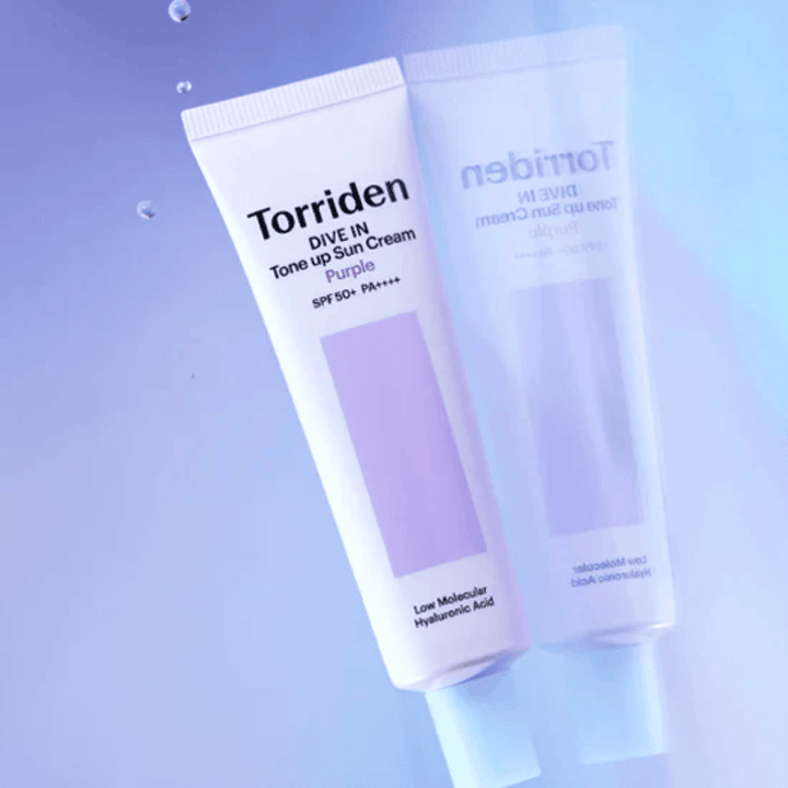 Torriden DIVE IN Tone Up Sun Cream Purple SPF50+ PA++++ photographed against a soft purple background that highlights the product's light-reflecting design.