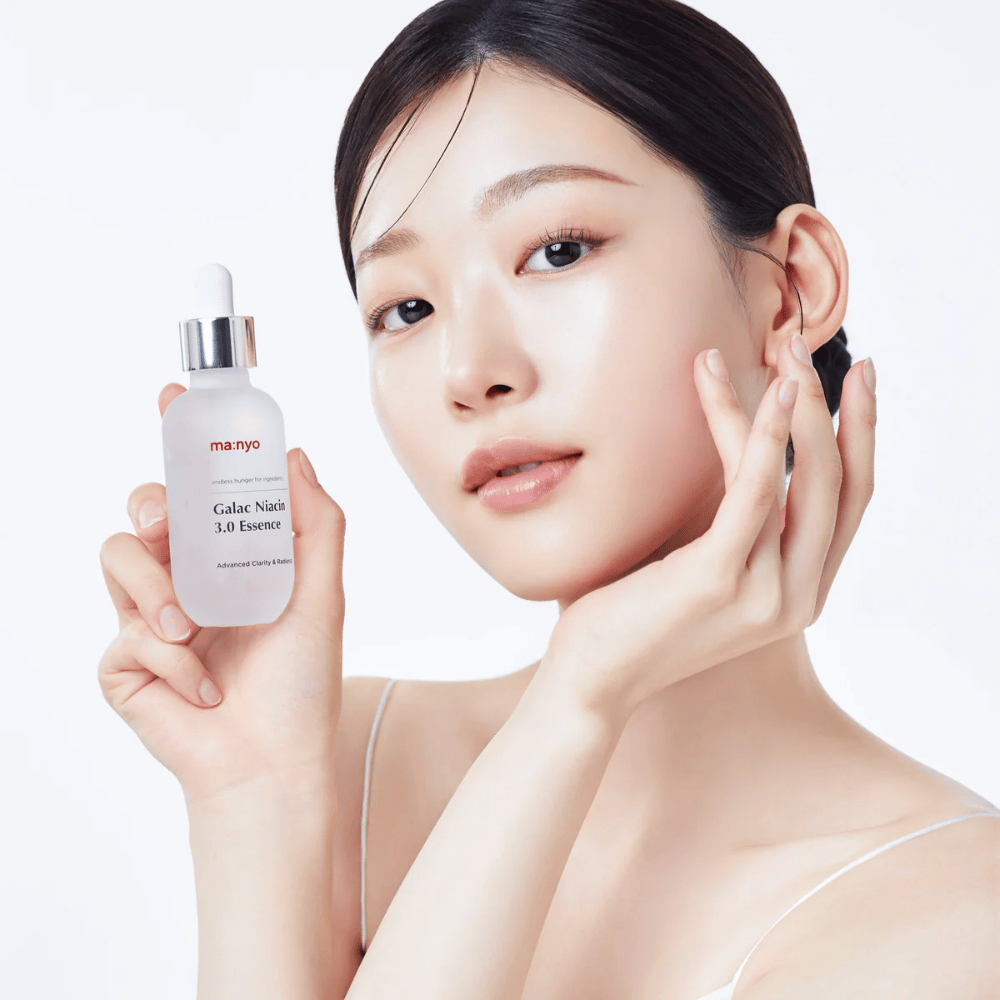 Woman with radiant skin holding Ma:nyo Galac Niacin 3.0 Essence – Korean essence that provides an even skin tone and natural radiance.