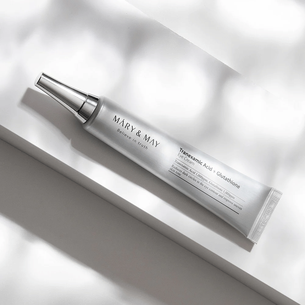 Close-up of Mary&May Tranexamic Acid + Glutathione Eye Cream with metal applicator, developed to brighten dark circles and even out the skin tone around the eyes.