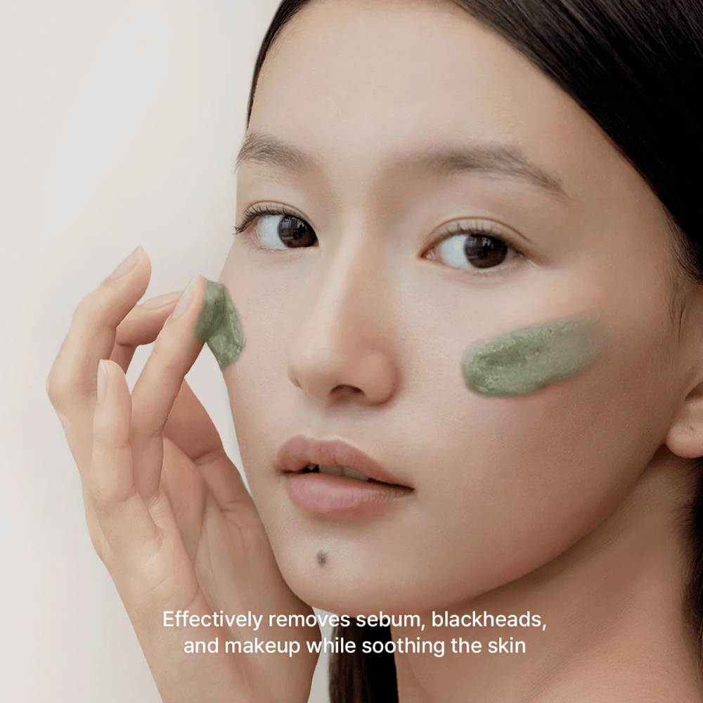 A model applies the green cleanser to the cheeks with a focus on removing sebum, blackheads, and makeup while soothing the skin and leaving it feeling balanced.