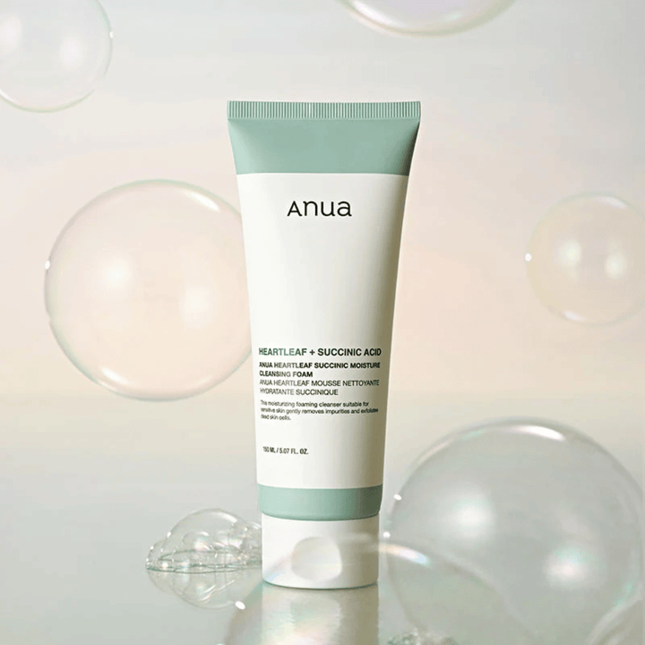 Product image of Anua Heartleaf + Succinic Acid Moisture Cleansing Foam surrounded by transparent bubbles. The image enhances the feeling of gentle cleansing, freshness, and airy foam.