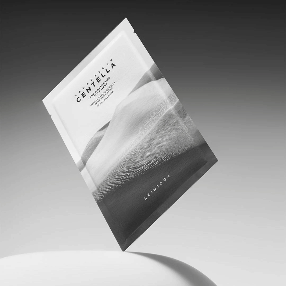 Sheet mask packaging from SKIN1004 floating against a gray background with a minimalist design.