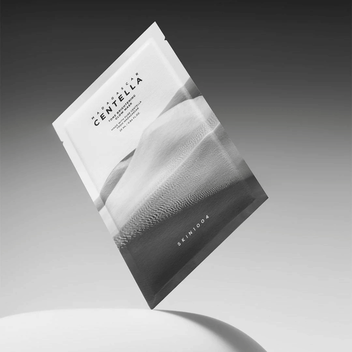 Sheet mask packaging from SKIN1004 floating against a gray background with a minimalist design.