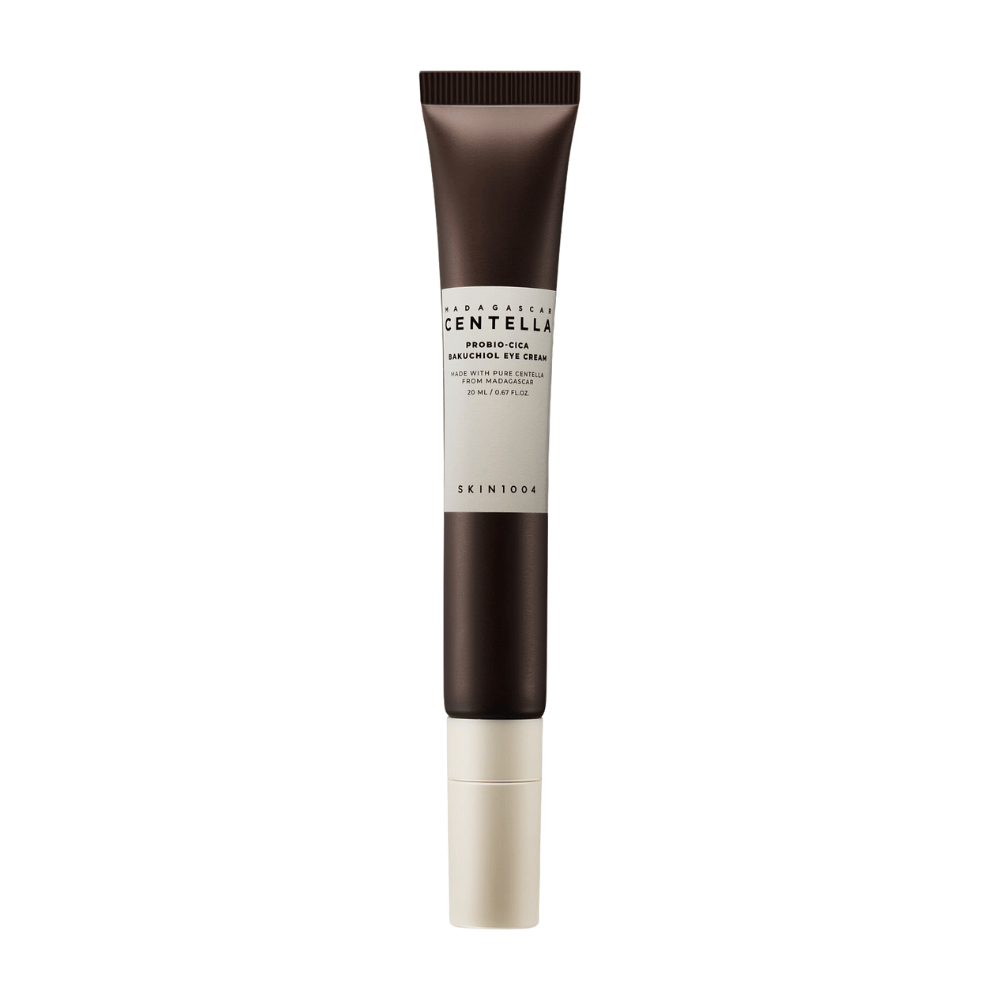 A tube of "Madagascar Centella Probio-Cica Bakuchiol Eye Cream" from SKIN1004. The product is designed for the eye area and contains ingredients such as centella from Madagascar and bakuchiol, known for their skincare and moisturizing properties. The tube is sleek with a dark brown color transitioning to white.
