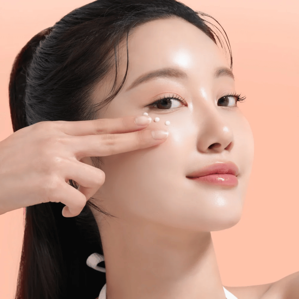Person applies Mixsoon PDRN Collagen Eye Serum under the eyes. The serum brightens, reduces puffiness, and strengthens the skin's firmness.