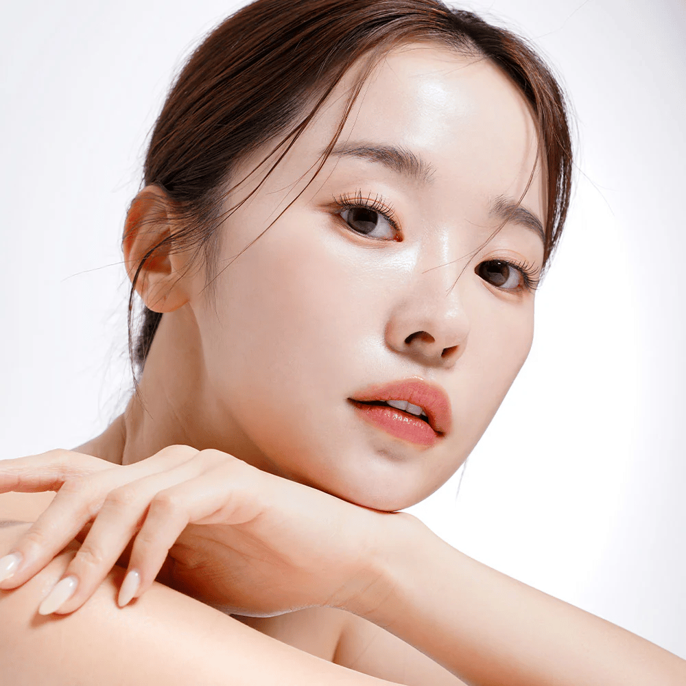 Close-up of a woman with radiant and hydrated skin. Her natural beauty is highlighted by soft lighting, giving a fresh and healthy look.