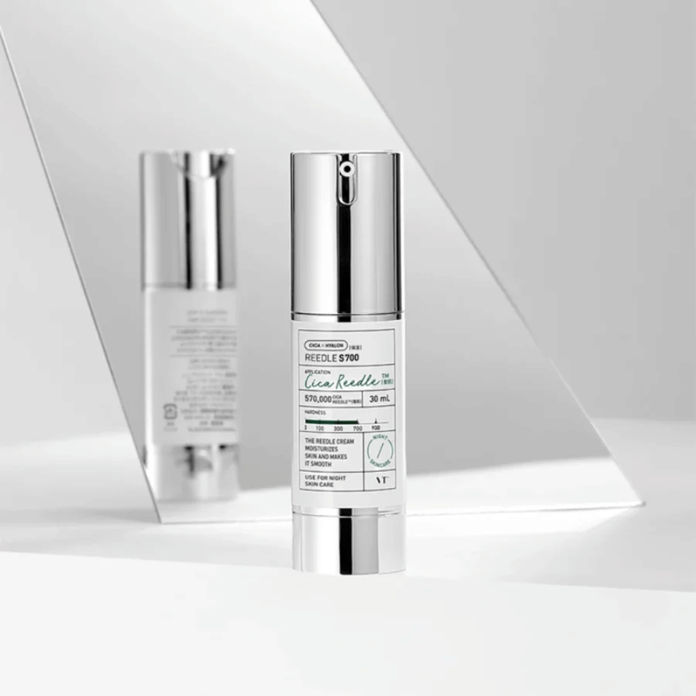 Reedle Shot 700 is a skincare serum in an elegant silver and white bottle. It contains 570,000 Cica Reedle, intended to hydrate and refine the skin. The product is recommended for nighttime use and is part of the daily skincare routine.