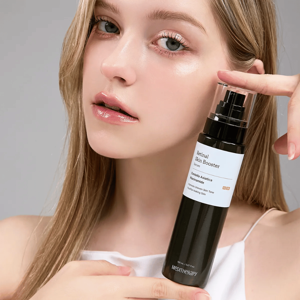 Person holding up Meditherapy Retinal Skin Booster Serum. The skin looks even, hydrated, and radiant – the result of retinal and niacinamide.