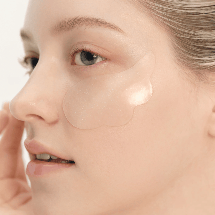 Close-up of a model applying Beauty of Joseon under eye patch under the eye for hydration, glow, and firming effect.