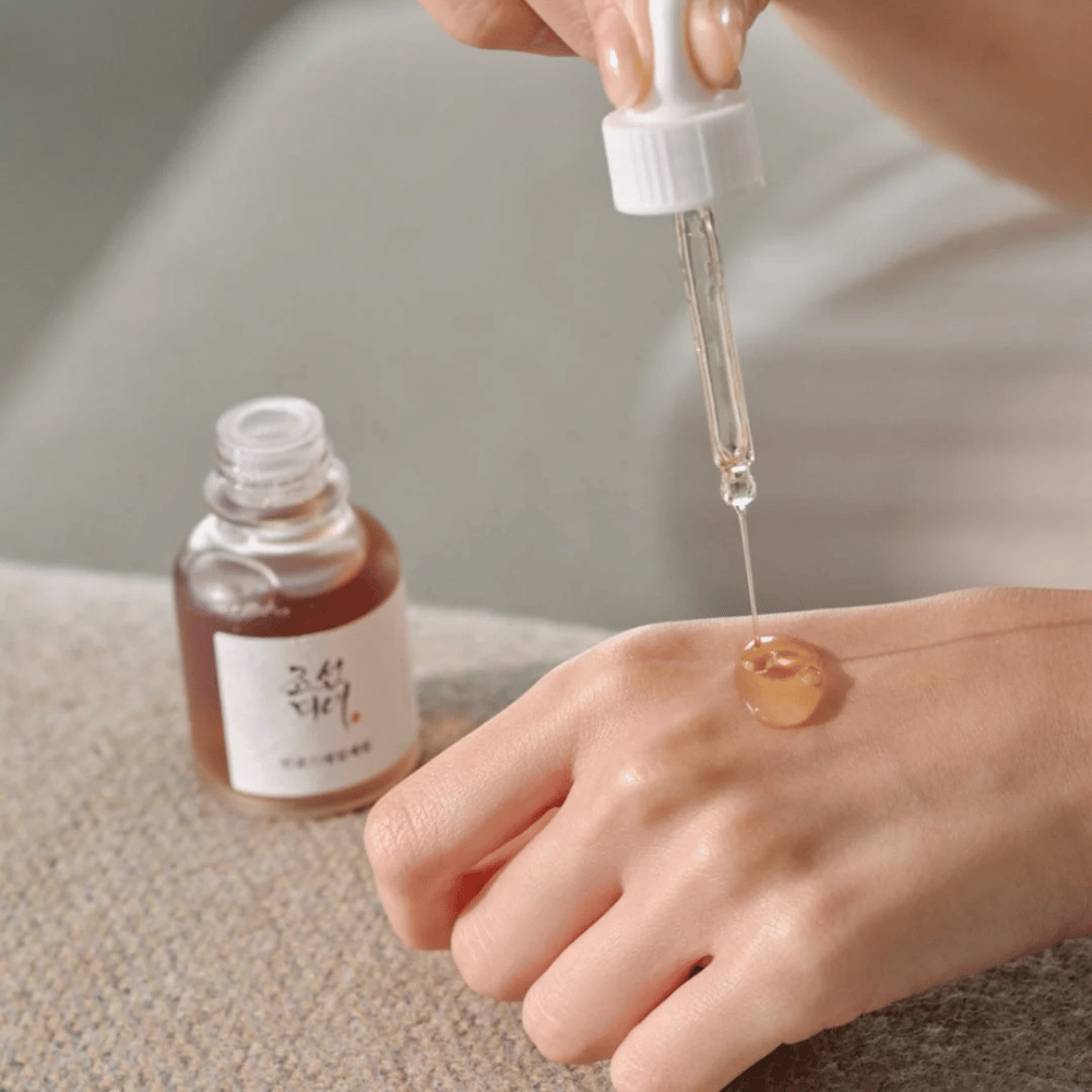 Dropper drips Beauty of Joseon Revive Serum Ginseng + Snail Mucin on the skin – Korean serum for elasticity and hydration.