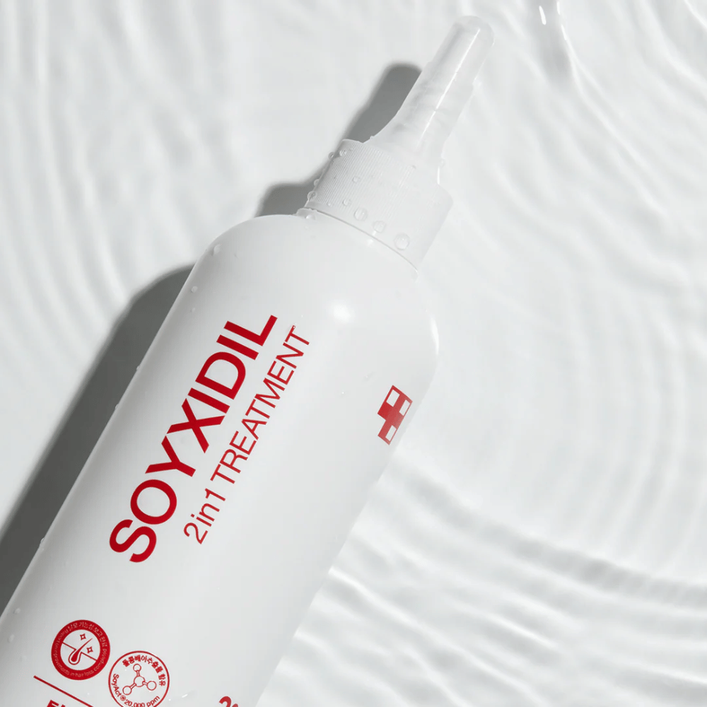 Bottle of Medicube Soyxidil 2in1 Treatment lies on a wavy water surface, symbolizing moisturizing and refreshing care.