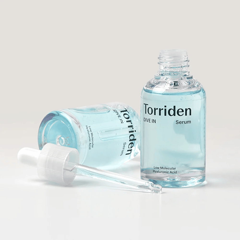 A bottle of Torridens DIVE-IN Low Molecule Hyaluronic Acid Serum 50ml next to a bottle of water, emphasizing hyaluronic acid serum and hydration.