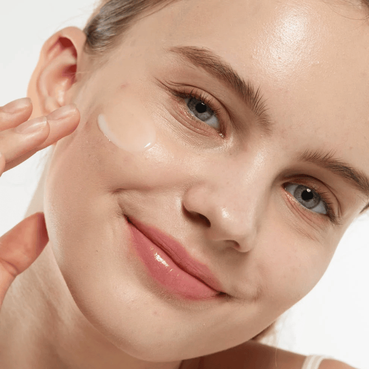 Model applying Medicube Zero Pore Serum 2.0 on the cheek, a pore-refining serum that provides smoother skin texture, hydration, and a natural glow.