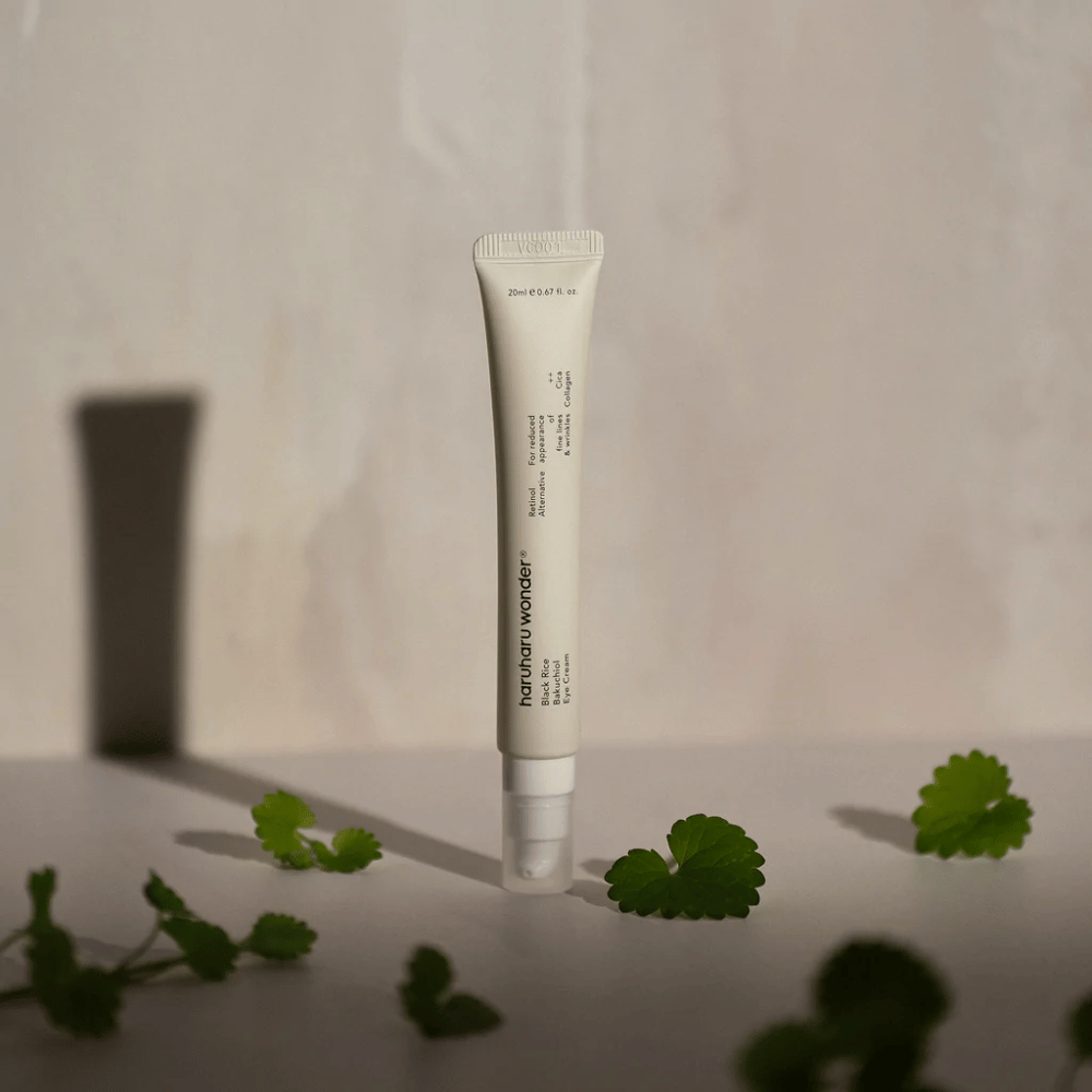 A tube Haruharu Wonder Black Rice Bakuchiol Eye Cream 20ml surrounded by green leaves, focused on the visibility of wrinkles and fine lines.