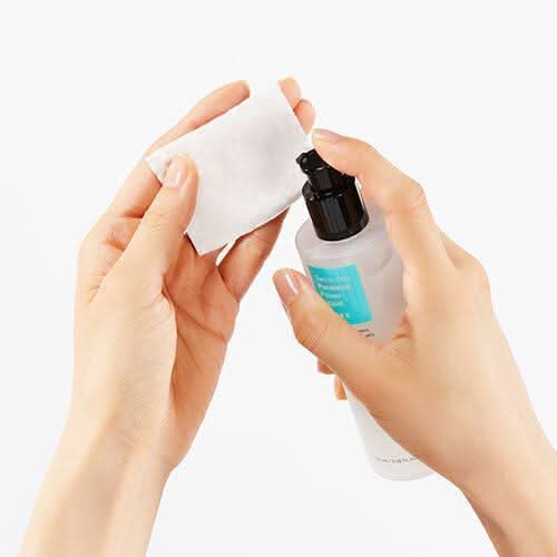 A hand demonstrating the use of COSRX Two In One Poreless Power Liquid 100ml for oily skin.